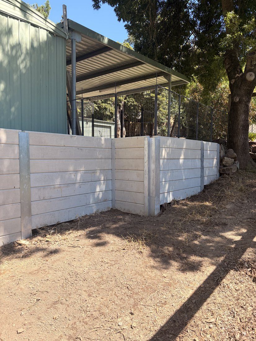The completed engineered retaining wall below the building it protects