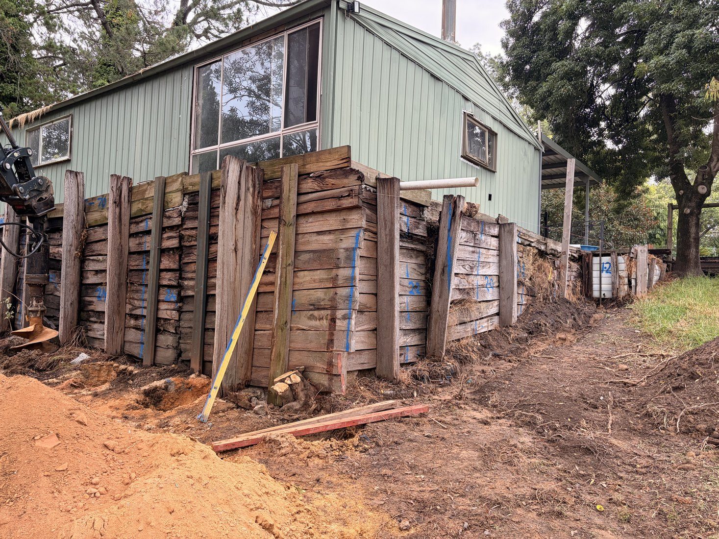 Excavating the footing line with the existing wall left standing