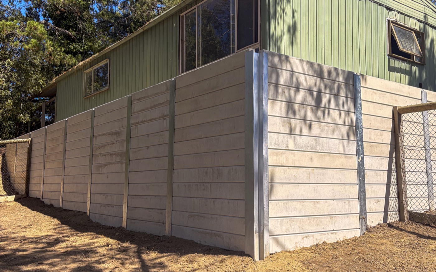 Completed concrete sleeper retaining wall along the boundary