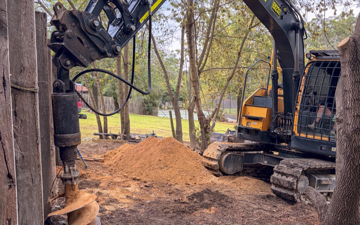Auger drilling new footings alongside the failing wall