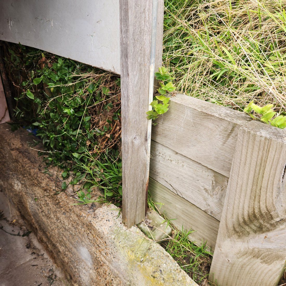 The failing timber retaining wall, with the embankment it was holding above the house